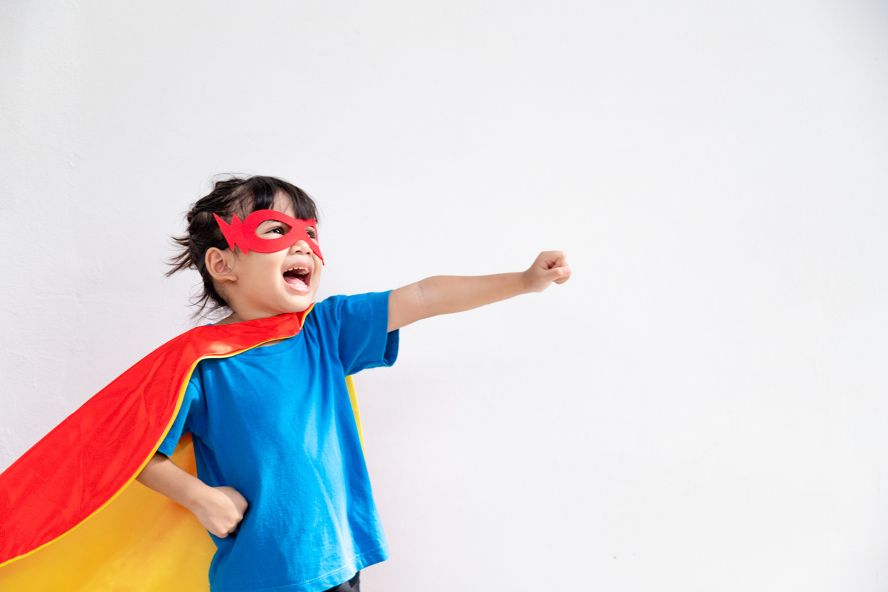 Little Child Girl Plays Superhero. Child on the White Background